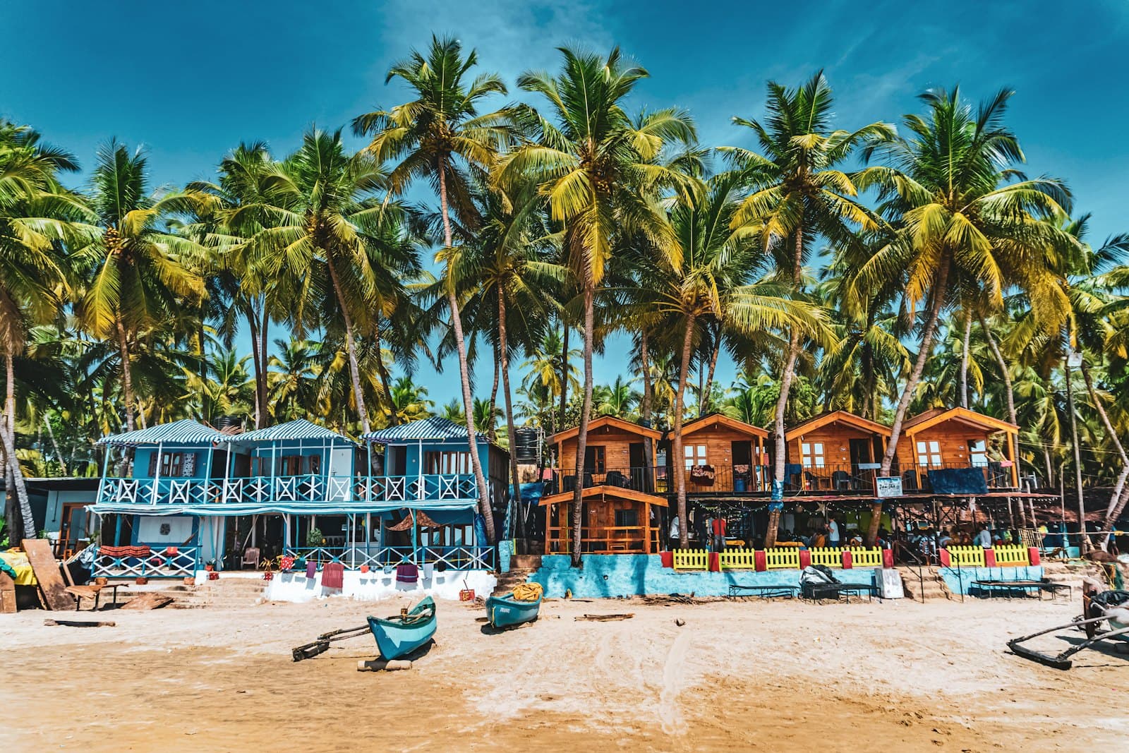 Colourful beach huts under palm trees in Goa