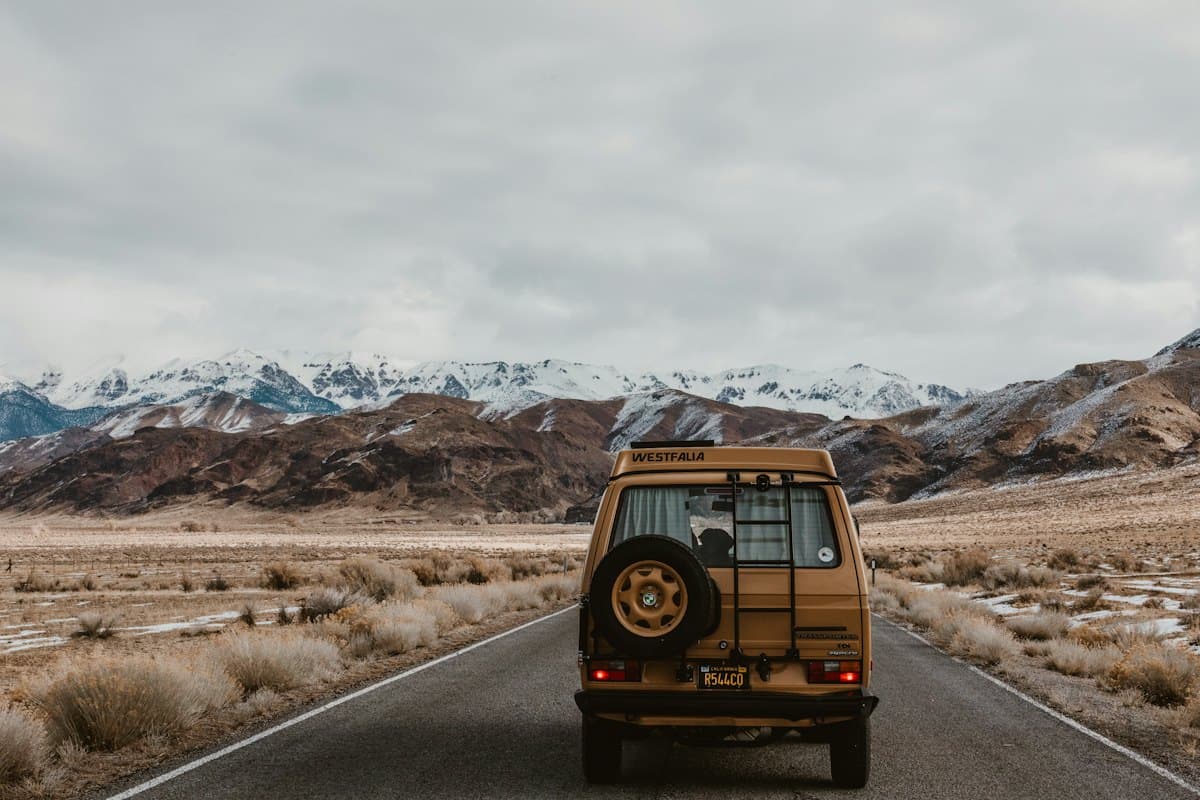 A vintage 4x4 on a road towards the mountains